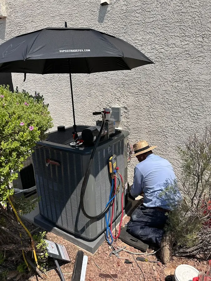 HVAC technician performing outdoor AC maintenance in Buxton